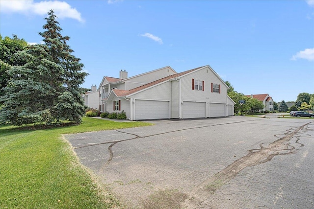 677 Wood River Ct, West Bend, WI 53095 - view of side of home featuring a garage, a yard, and a chimney