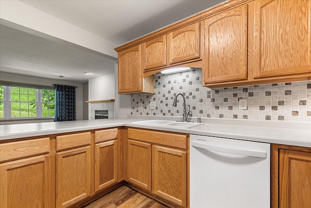 677 Wood River Ct, West Bend, WI 53095 - kitchen with dishwasher, decorative backsplash, light countertops, and a tiled fireplace
