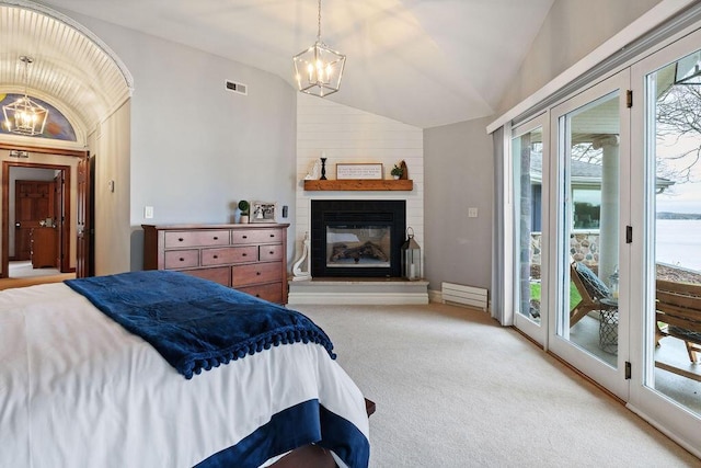 900 Hawks Holw, Delafield, WI 53018 - bedroom with a chandelier, lofted ceiling, access to exterior, light carpet, and a fireplace