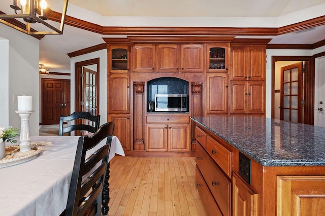 900 Hawks Holw, Delafield, WI 53018 - kitchen with stainless steel microwave, brown cabinets, glass insert cabinets, dark stone countertops, and light wood finished floors