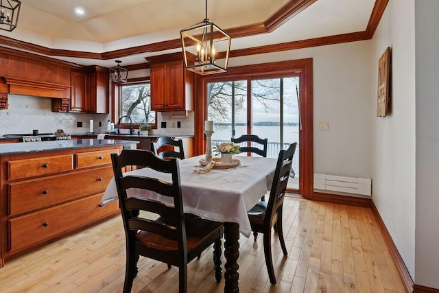 900 Hawks Holw, Delafield, WI 53018 - dining area featuring a chandelier, a raised ceiling, ornamental molding, light wood-style flooring, and a water view
