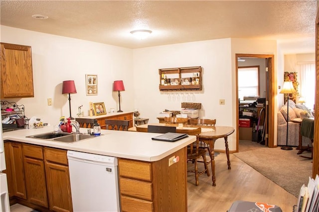 3155 Craig Rd Unit 3155, Eau Claire, WI 54701 - kitchen with dishwasher, a peninsula, a textured ceiling, brown cabinets, and light wood finished floors
