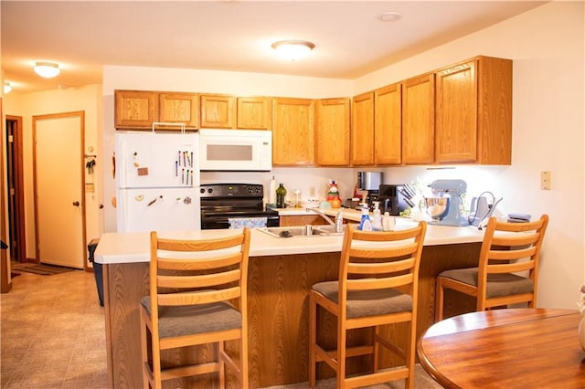 3215 Craig Rd Unit 3215, Eau Claire, WI 54701 - kitchen with white appliances, a peninsula, light countertops, a kitchen bar, and brown cabinets