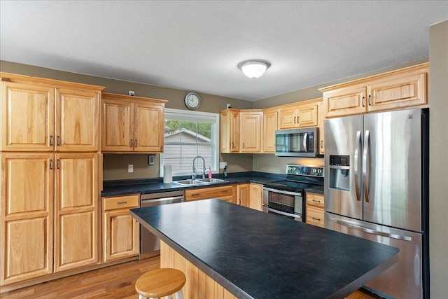 1125 W State St, Marshfield, WI 54449 - kitchen with appliances with stainless steel finishes, light brown cabinets, dark countertops, and light wood-style flooring