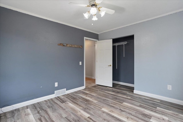 1125 W State St, Marshfield, WI 54449 - unfurnished bedroom with wood finished floors, crown molding, a closet, and a ceiling fan