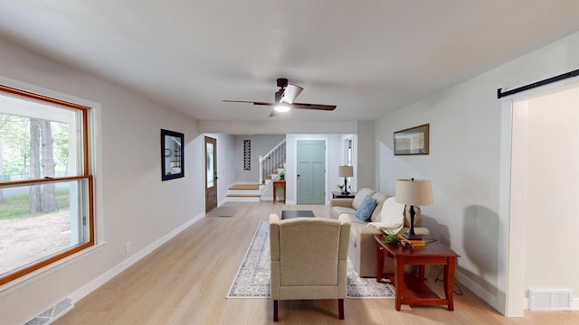 801 S Maryknoll Ave, Marshfield, WI 54449 - living area with a barn door, light wood-type flooring, stairs, and a ceiling fan