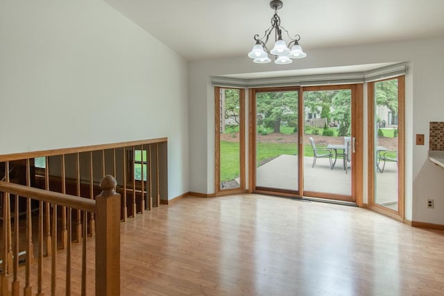 5947 Pilgrim Way, Mount Pleasant, WI 53406 - empty room with wood finished floors and a chandelier