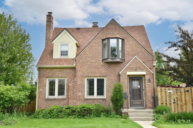 3786 S 35th St, Greenfield, WI 53221 - tudor house with a chimney, brick siding, and roof with shingles