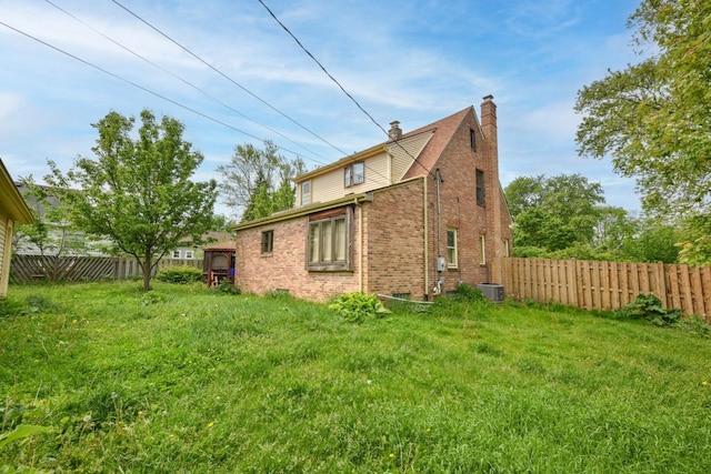 3786 S 35th St, Greenfield, WI 53221 - back of property with a chimney, a fenced backyard, and brick siding