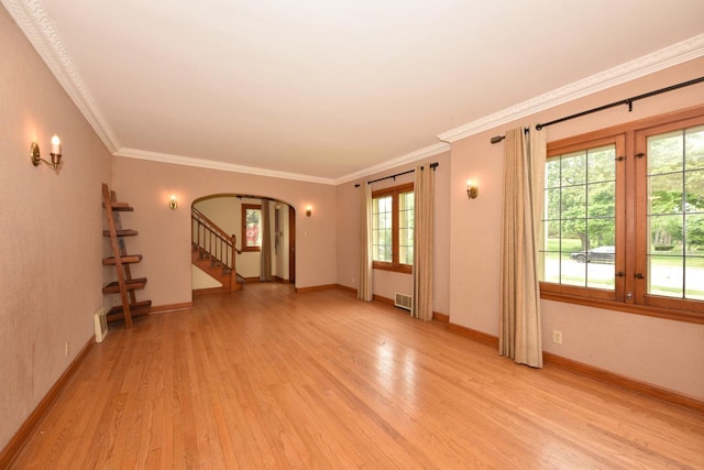 3786 S 35th St, Greenfield, WI 53221 - spare room featuring arched walkways, light wood-style flooring, ornamental molding, and stairs