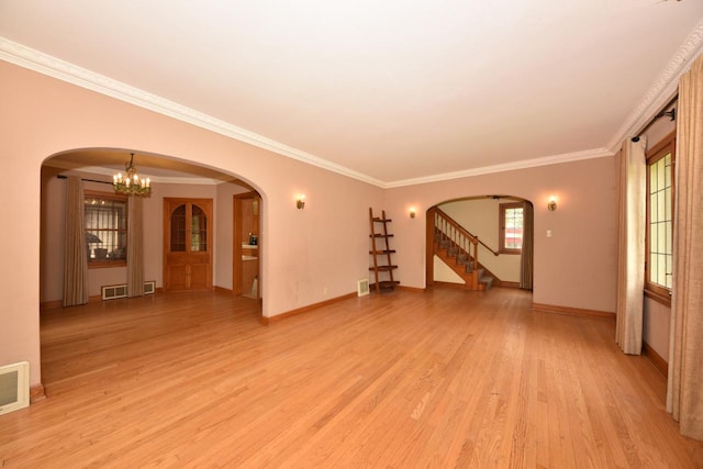 3786 S 35th St, Greenfield, WI 53221 - unfurnished living room with light wood-type flooring, arched walkways, crown molding, a chandelier, and stairs