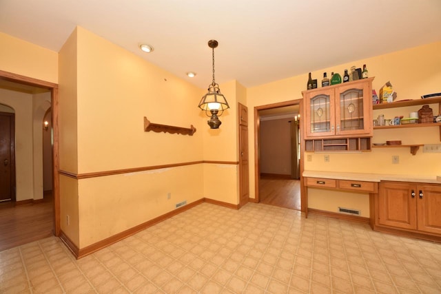 3786 S 35th St, Greenfield, WI 53221 - kitchen with open shelves, light flooring, light countertops, arched walkways, and glass insert cabinets