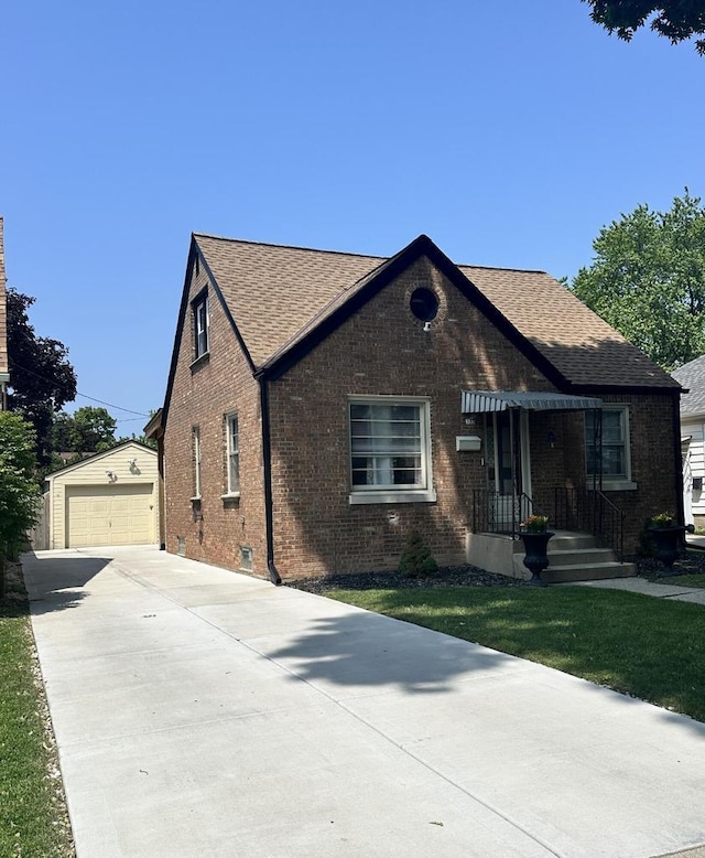 323 S 79th St, Milwaukee, WI 53214 - tudor home featuring an outdoor structure, brick siding, roof with shingles, driveway, and a detached garage
