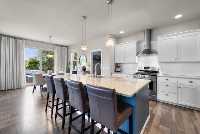 405 Blue Moon Dr, Verona, WI 53593 - kitchen featuring stainless steel gas range oven, wall chimney exhaust hood, backsplash, a kitchen bar, and recessed lighting