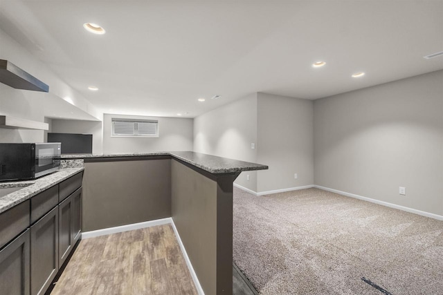 405 Blue Moon Dr, Verona, WI 53593 - kitchen featuring black microwave, recessed lighting, light stone countertops, a peninsula, and light carpet