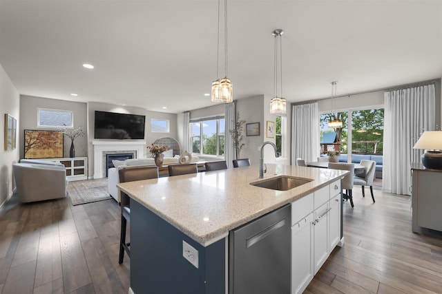 405 Blue Moon Dr, Verona, WI 53593 - kitchen with dishwasher, a center island with sink, white cabinetry, light stone counters, and a fireplace