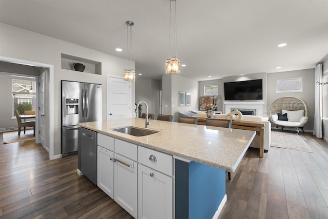 405 Blue Moon Dr, Verona, WI 53593 - kitchen with stainless steel appliances, an island with sink, light stone counters, recessed lighting, and dark wood-style flooring