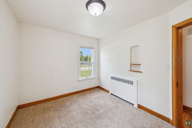 120 W 12th St, Ashland, WI 54806 - carpeted empty room featuring radiator and baseboards