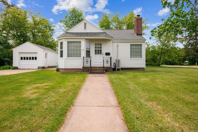 120 W 12th St, Ashland, WI 54806 - shotgun-style home with an outbuilding, a chimney, roof with shingles, a garage, and a front lawn