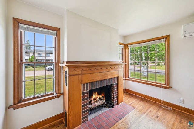 120 W 12th St, Ashland, WI 54806 - unfurnished living room featuring wood finished floors, a fireplace, plenty of natural light, and a wall mounted AC