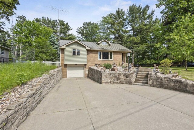 175 Old Wausau Rd, Stevens Point, WI 54481 - view of front of house featuring driveway, an attached garage, a standing seam roof, a metal roof, and stairway