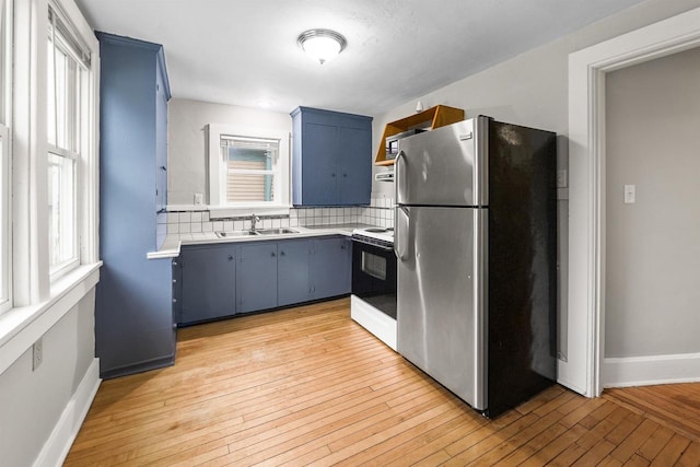 274 E 1st St, Fond Du Lac, WI 54935 - kitchen featuring freestanding refrigerator, electric range, light countertops, blue cabinetry, and tasteful backsplash
