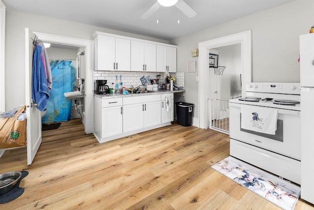 274 E 1st St, Fond Du Lac, WI 54935 - kitchen with white electric stove, light wood-style flooring, ceiling fan, white cabinets, and tasteful backsplash
