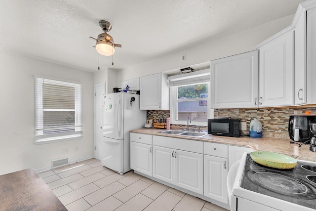 4951 N 49th St, Milwaukee, WI 53218 - kitchen with white appliances, light countertops, backsplash, white cabinets, and a textured ceiling