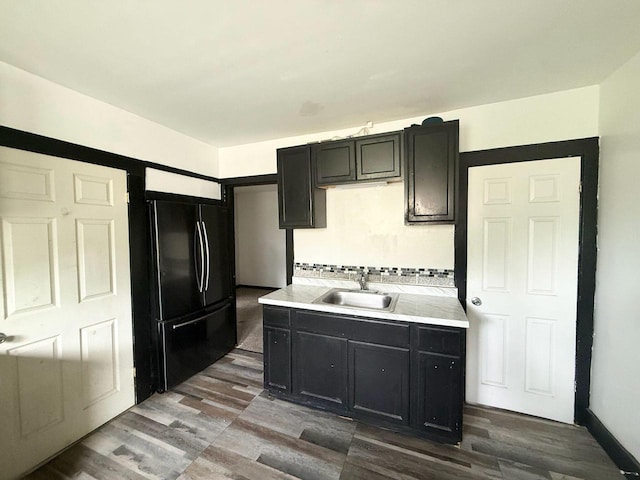 4668 N 29th St, Milwaukee, WI 53209 - kitchen with freestanding refrigerator, dark cabinetry, light countertops, and dark wood-style floors