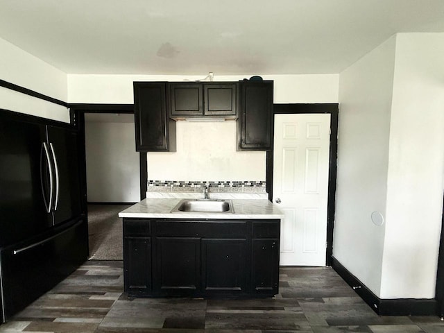 4668 N 29th St, Milwaukee, WI 53209 - kitchen with black fridge, dark wood finished floors, dark cabinetry, and backsplash