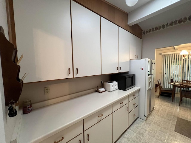 1011 19th Ave S, Wisconsin Rapids, WI 54495 - kitchen with beam ceiling, black microwave, white fridge with ice dispenser, white cabinets, and light countertops