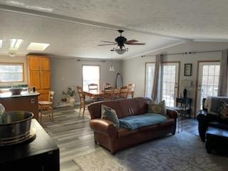 1116 Fawn Dr, Grand Marsh, WI 53936 - living area featuring wood finished floors, vaulted ceiling, ceiling fan, and a textured ceiling