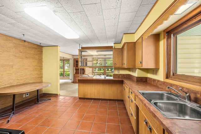 2908 Prais St, Stevens Point, WI 54481 - kitchen with dark tile patterned flooring, dark countertops, brown cabinetry, and a peninsula