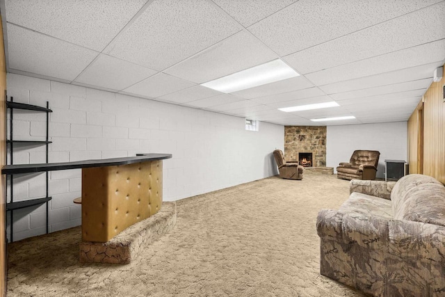 2908 Prais St, Stevens Point, WI 54481 - living area with a stone fireplace, concrete block wall, a drop ceiling, and carpet floors