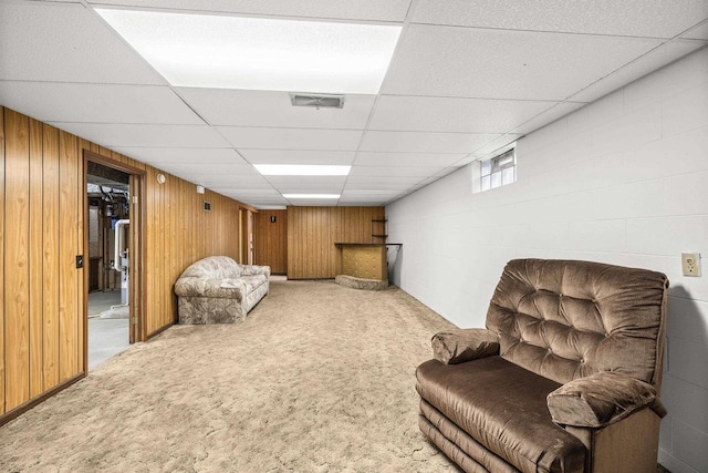 2908 Prais St, Stevens Point, WI 54481 - living area with carpet, a paneled ceiling, and wood walls