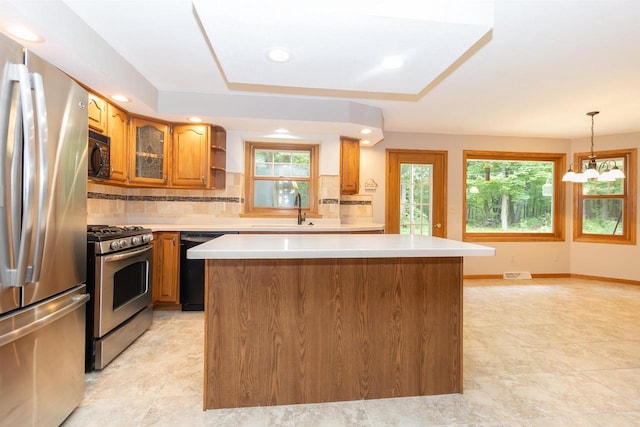 N2559 Pleasant View Ln, Waupaca, WI 54981 - kitchen with black appliances, brown cabinetry, a center island, backsplash, and light countertops