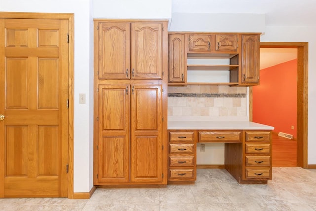 N2559 Pleasant View Ln, Waupaca, WI 54981 - kitchen with backsplash, light countertops, built in desk, open shelves, and brown cabinetry
