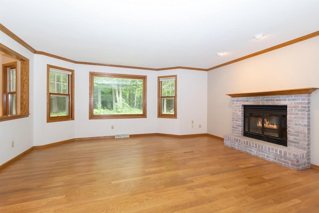 N2559 Pleasant View Ln, Waupaca, WI 54981 - unfurnished living room with plenty of natural light, light wood-type flooring, a brick fireplace, and crown molding