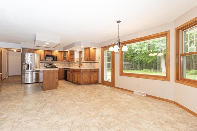 N2559 Pleasant View Ln, Waupaca, WI 54981 - kitchen with stainless steel fridge with ice dispenser, black microwave, light countertops, brown cabinets, and a chandelier