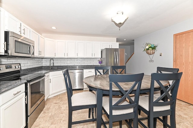 2147 E Broadway Unit A, Waukesha, WI 53186 - kitchen featuring appliances with stainless steel finishes, backsplash, white cabinets, and dark stone countertops