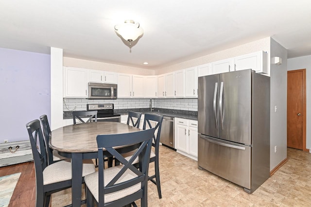 2147 E Broadway Unit A, Waukesha, WI 53186 - kitchen with appliances with stainless steel finishes, white cabinetry, and decorative backsplash