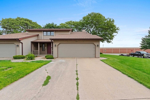 2409 Cedar Ridge Ct Unit D, Green Bay, WI 54313 - view of front of property featuring a front lawn, a garage, a chimney, and concrete driveway