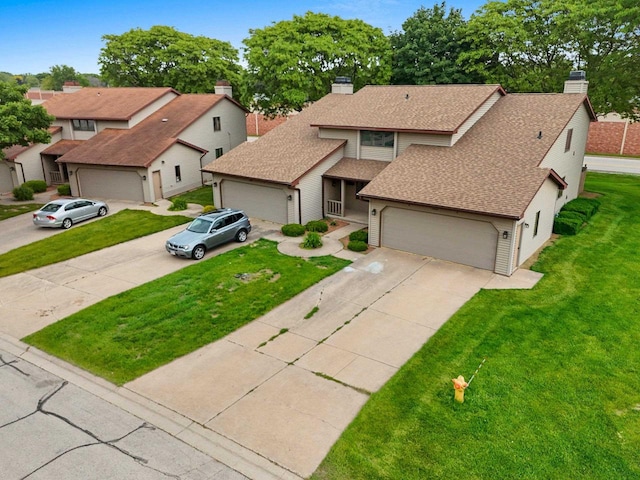 2409 Cedar Ridge Ct Unit D, Green Bay, WI 54313 - view of front of home featuring a chimney, concrete driveway, a front yard, and roof with shingles