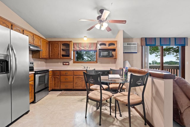2409 Cedar Ridge Ct Unit D, Green Bay, WI 54313 - kitchen featuring stainless steel appliances, brown cabinetry, ceiling fan, light countertops, and under cabinet range hood