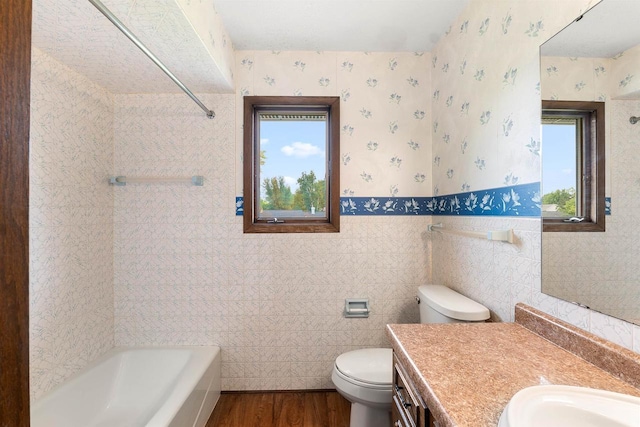 614 8th St, Fond Du Lac, WI 54935 - full bath with wood finished floors, vanity, wallpapered walls, a wainscoted wall, and tile walls