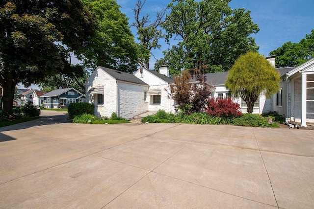 645 Wisconsin St, Oshkosh, WI 54901 - view of front of home featuring stone siding, a chimney, and a residential view