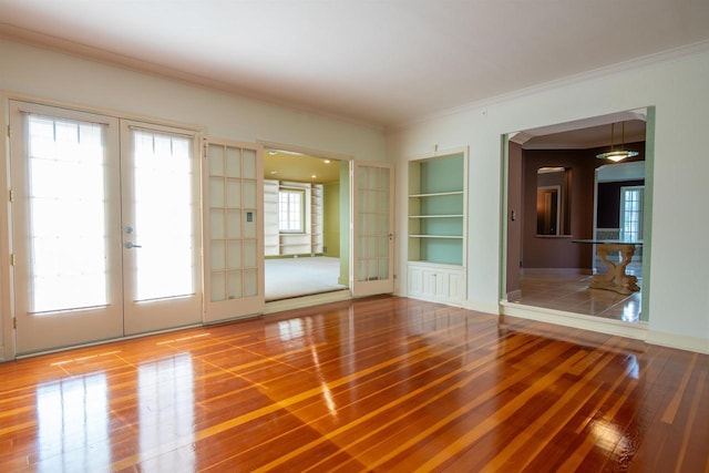 645 Wisconsin St, Oshkosh, WI 54901 - empty room with french doors, wood finished floors, ornamental molding, and built in shelves