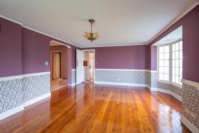 645 Wisconsin St, Oshkosh, WI 54901 - empty room with a wainscoted wall, wood finished floors, arched walkways, crown molding, and a chandelier