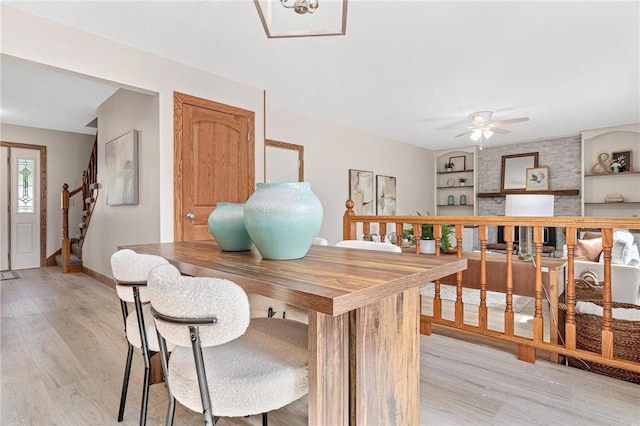 3203 Canterbury Cir, Saint Paul, MN 55125 - dining room with light wood-style flooring, a ceiling fan, stairs, and built in shelves
