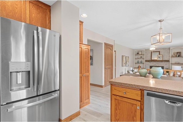 3203 Canterbury Cir, Saint Paul, MN 55125 - kitchen with stainless steel appliances, light wood-style floors, light countertops, a ceiling fan, and decorative light fixtures